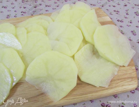 Картофель почистить и нарезать тонкими слайсами.