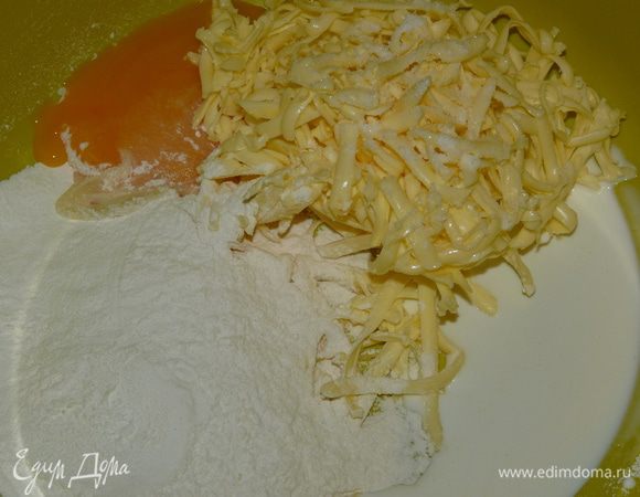 Сливочное масло натереть на терке. Добавить желток (белок пригодится для начинки), сливки, муку, соль и куркуму, и замесить тесто.