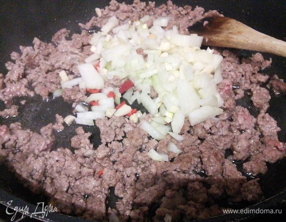 Добавить мелко рубленный лук, чеснок и перец чили (предварительно удалив из него перепонки и семена (остроту регулируйте по своему вкусу). Обжарить вместе в течение нескольких минут. Посолить и поперчить. 