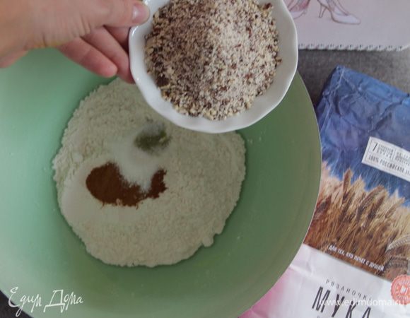 Просеять муку через сито с содой и разрыхлителем, добавить специи и измельченный миндаль.