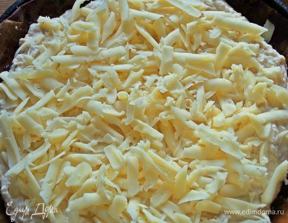 Насыпать сыр равномерно по всему тесту.