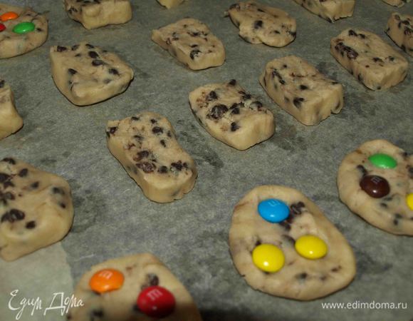 Выкладываем печенье на противень, смазанный маслом или застеленный пекарской бумагой. Печенье увеличится, поэтому выкладывать надо на расстоянии. 
Печенье можно украсить сверху драже M&M’s. 