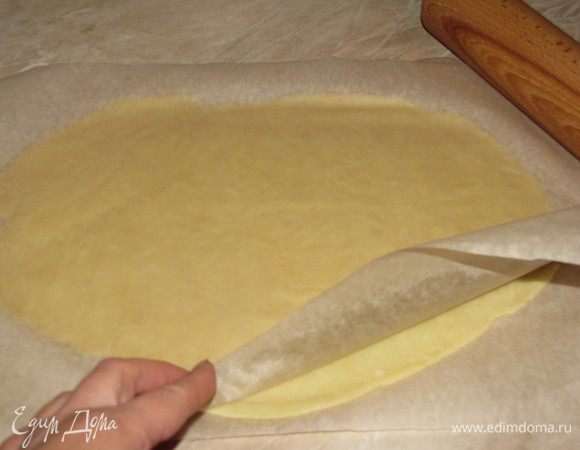 Тесто разделить на две части. Одну вернуть в холодильник, вторую раскатать между двумя листами пергамента, придавая форму прямоугольника размером примерно 20х25 см. Прямоугольник у меня не получился, а получился овал, я его потом немного подрезала.