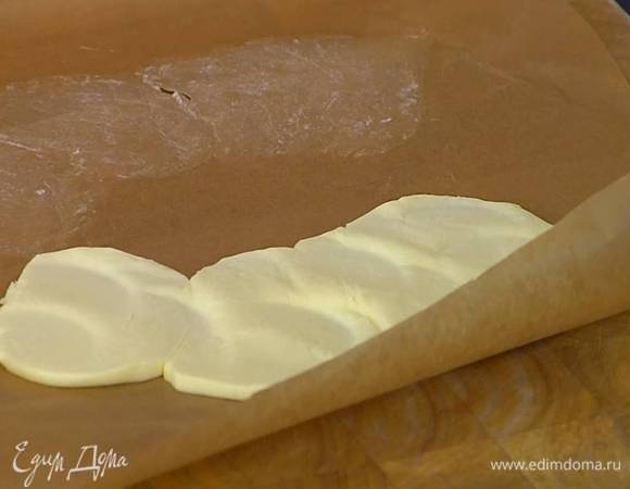 Предварительно охлажденное сливочное масло нарезать пластинками, поместить между двумя слоями бумаги для выпечки и скалкой или молоточком отбить все так, чтобы получился довольно тонкий пласт.