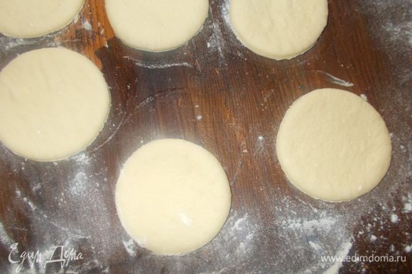 Вырезать кружочки (стаканом или специальным кругом для пирожных) диаметром 5 — 6 см. Собрать обрезки в ком и опять раскатать в пласт. Вырезать кружочки. И так все тесто