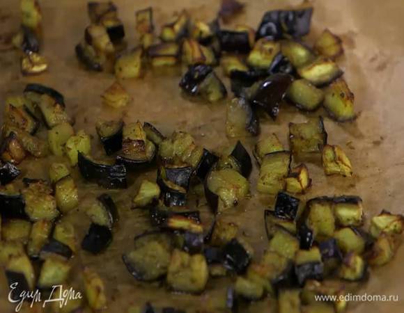 Противень выстелить бумагой для выпечки, выложить нарезанный баклажан, слегка посолить, поперчить, посыпать зирой, немного сбрызнуть оливковым маслом и запекать в разогретой духовке 10‒15 минут.