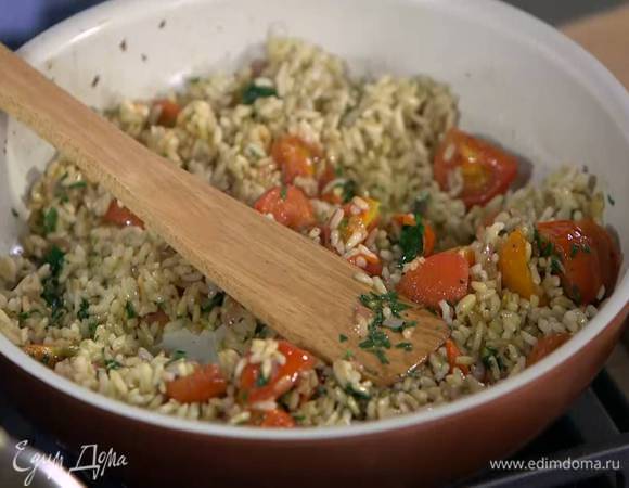 К помидорам с луком и чесноком выложить отваренный рис, измельченную петрушку, все перемешать и немного прогреть.