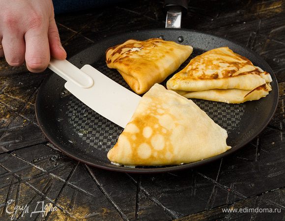 Обжарить начиненные блинчики на разогретой сковороде с двух сторон.