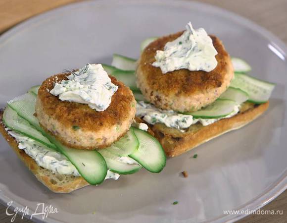 Обжаренную сторону булок смазать заправкой, выложить полоски огурца и рыбную котлету, сверху еще немного смазать заправкой.
