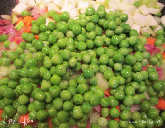 Добавляем сельдерей, морковь, перец чили. Обжариваем 2 — 3 минуты. Добавляем помидоры и готовим 5 минут. Затем кладем горошек.