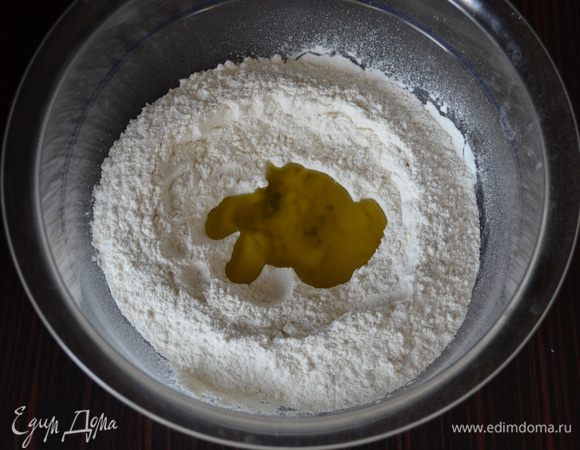 Просеять в миску 200 г муки, добавить соль. Сделать в муке углубление и добавить оливковое масло.