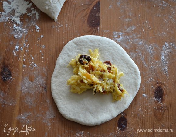 Каждую часть скатать в колобок, слегка придавливая ладонью, растянуть в лепешку (можно и скалкой раскатать). В центр лепешки положить примерно столовую ложку начинки.