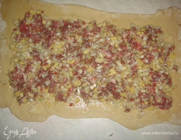 Тесто и фарш разделить на две части. Тесто раскатать в прямоугольник, смазать подсолнечным маслом. Выложить часть фарша и свернуть в рулет. Края рулета защипать. Также поступить с оставшейся частью теста и фарша.