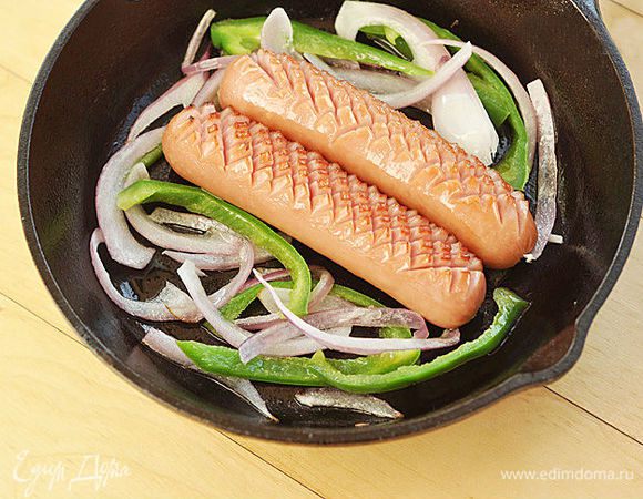 Положить на сковороду сосиски и обжарить их с двух сторон в течение 2—х минут на среднем огне. 
