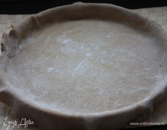 Смажьте форму для выпечки сливочным маслом. Тесто тонко раскатайте и выложите в форму — края должны чуть свисать. Основание будущего пирога смажьте взбитым яичным белком.