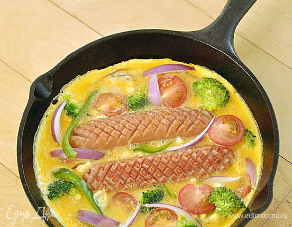 Когда края омлета схватятся, поставить сковороду в духовку, разогретую до 170°С. Выпекать фриттату 8 минут.