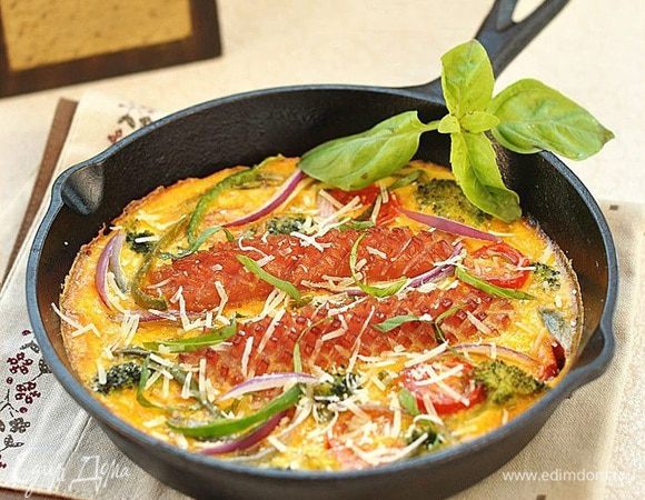 Готовую фриттату украсить нарезанными листьями базилика и тертым пармезаном.
