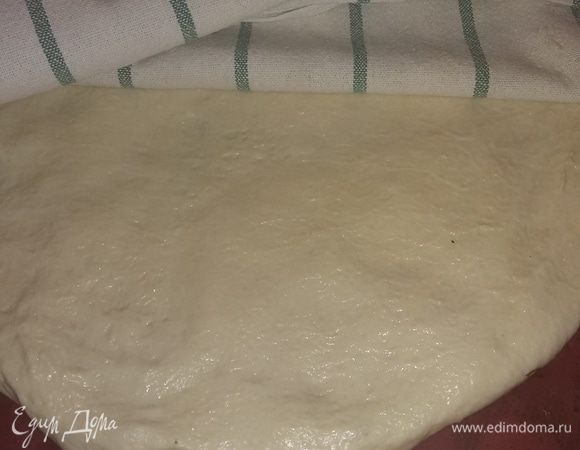 Замесить тесто и оставить его подходить на 2 часа. Я делаю это в хлебопечке. 
Если делать руками, то надо дрожжи развести в 80 мл теплой воды. Добавить муки, влить еще 100 мл воды, 3 ст. л. оливкового масла, добавить соль. Замесить тесто и оставить его подниматься на 2 часа.
Через два часа тесто растянуть руками по форме противня. Накрыть полотенцем и дать еще подойти 1 час.