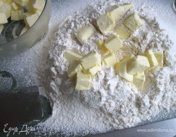 Достать масло из морозильной камеры, частями (в три приема) добавлять его к муке, рубить ножом, помогая себе лопаткой. 