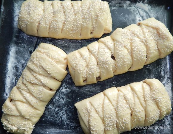 Косички выложить на противень присыпанный мукой. Дать им постоять минут 15 — 20, чтобы они поднялись. Взбить 1 яйцо и смазать им косички. Сверху посыпать кунжутом.