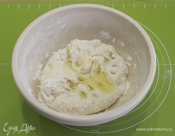 Затем начинайте месить тесто руками, собирая всю муку со стенок. Добавьте оливковое масло.