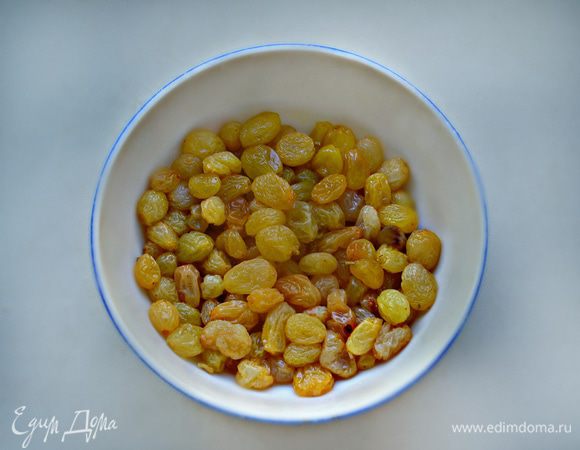 Вымойте изюм, залейте его коньяком или апельсиновым соком. Оставьте пропитаться на 10 — 15 минут.