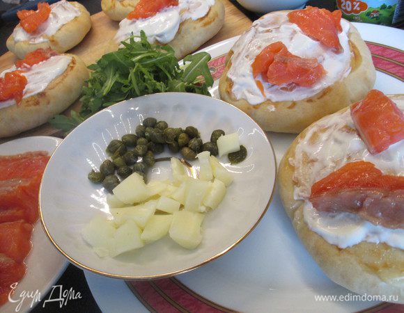 Выкладываем ломтики лосося, руколу, раскрошенный мягкий сыр (можно вместо моцареллы  взять адыгейский, а лучше и тот, и другой), каперсы, солим, перчим.