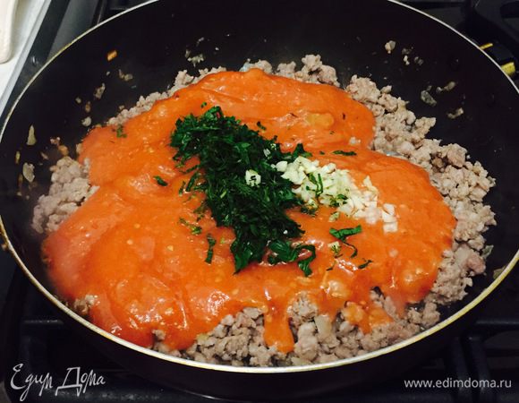 Обжариваем мелко нарезанный лук, добавляем фарш (обжариваем до готовности) и добавляем нашу пасту, зелень по вкусу и чеснок. Обжариваем массу еще минуты 2 — 3.