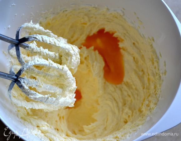 Яйца разделить на белки и желтки. Размягченное сливочное масло (хорошего качества) взбить электромиксером с сахаром до состояния пышной светлой массы. По одному добавить яичные желтки, продолжая взбивать до однородной массы.
