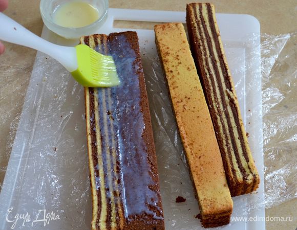 Слегка разогреть сгущенное молоко. Смазать внутренние бока и «склеить» между собой первые два брусочка, расположив и повернув их так, чтобы черно-белые полоски в одном брусочке располагались по горизонтали, а в другом по вертикали. Оставшиеся два брусочка «приклеить» в обратном порядке, чередуя горизонтальные и вертикальные полоски (см. фото).