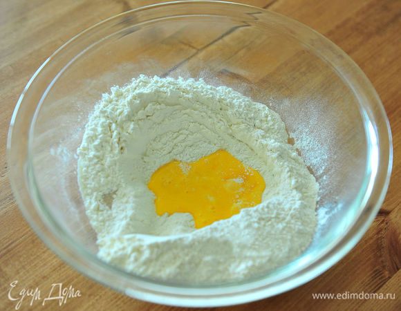 Сделать углубление и влить яйцо. Перемешать по центру спатулой. Добавить воду и все перемешать спатулой.