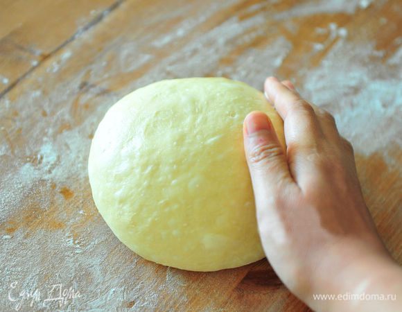 Присыпать поверхность стола мукой. Переложить тесто на стол и обмять руками. Оставить тесто на 15 минут.