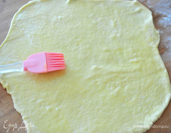 Тонко раскатать тесто в пласт. Растопить сливочное масло и смазать тесто маслом с помощью кисти.