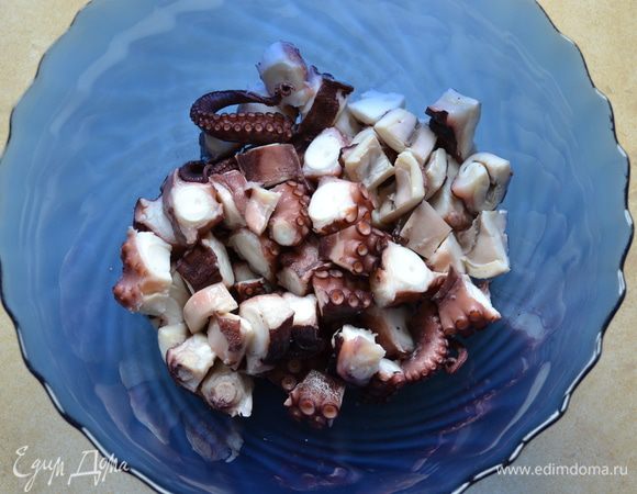 Нарезать щупальца и голову осьминога небольшими кусочками, схожими по размеру с кубиками картофеля. Выложить в миску вместе с картофелем.