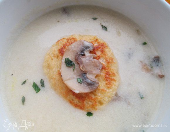 Теперь собираем наш крем-суп: укладываем на дно тарелки грибы, вливаем крем-суп, кладем равиоли. На них — немного грибов и посыпаем зеленью.