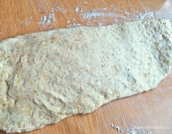 Перенести на стол или доску, вытянуть в широкий пласт. Второй вариант формовки: разделить тесто на 2 части, одну оставить в виде буханочки, вторую раскатать, разрезать и сплести косу. Косу положить сверху буханочки и так выпекать.