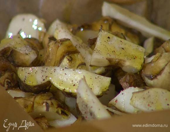 Небольшой глубокий противень выстелить бумагой для выпечки, выложить топинамбур, посолить, поперчить, сбрызнуть оливковым маслом, перемешать и запечь в разогретой духовке.