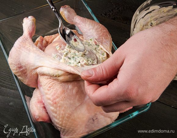 Под кожу курицы со стороны грудки, стараясь не повредить кожу, ввести половину полученной смеси. Сделать небольшие надрезы на ножках и смазать внутри полученной смесью.