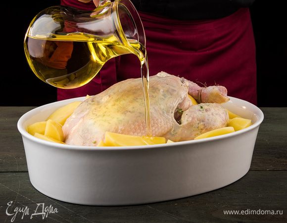 Картофель почистить, нарезать крупно, сбрызнуть оставшимся растительным маслом, посолить, разложить вокруг курицы. Запекать в разогретой духовке около часа.
