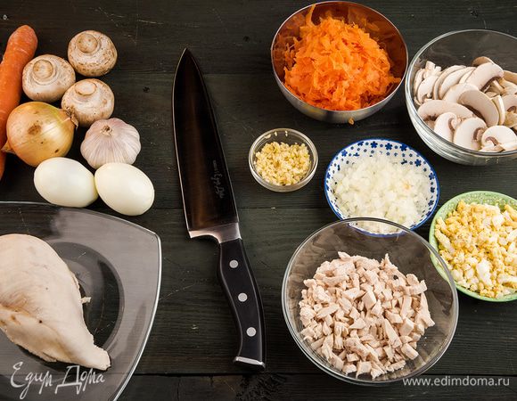 Куриное филе отварить в подсоленной воде. Нарезать произвольными небольшими кусочками. Яйца отварить и нарезать мелко. Морковь натереть на крупной терке, чеснок измельчить. 
