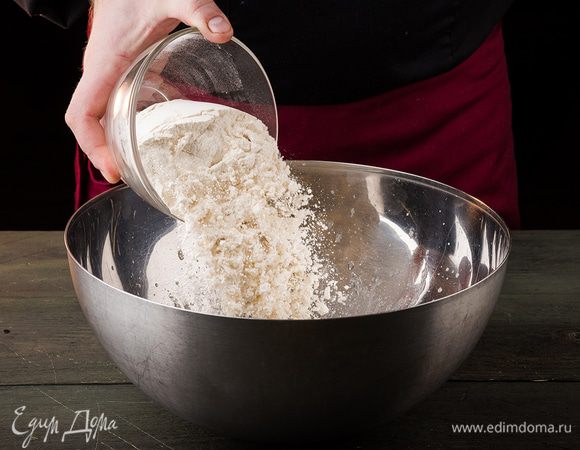 Далее всыпаем муку и замешиваем тесто. Накрываем полотенцем и оставляем в тепле на 30 — 40 минут. Когда тесто увеличится, его необходимо разделить на два шара. Накрываем шарики теста полотенцем и снова оставляем на 15 — 20 минут.