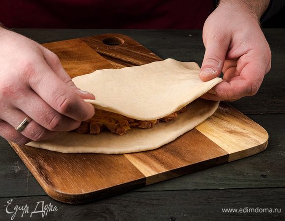 На половину круга кладем начинку. Накрываем начинку второй половиной теста и защипываем при помощи вилки.