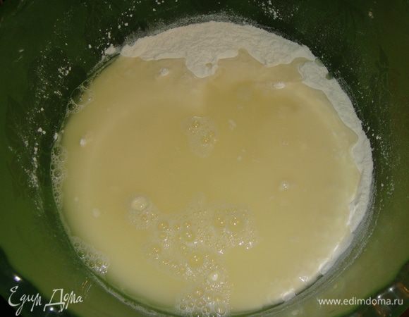 Влить сыворотку (воду) и замесить тесто ложкой.