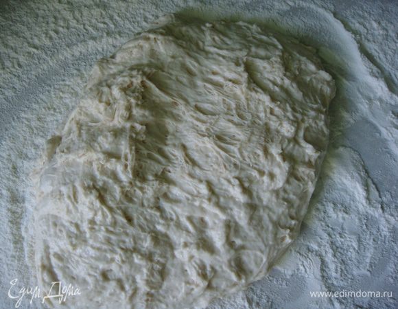 Стол сильно присыпать мукой и аккуратно выложить тесто.