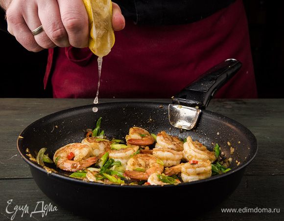 Перец чили, зеленый лук тонко порезать наискосок, добавить к креветкам, посолить и перемешать. Из лимона выжать сок и обжарить все до готовности. Авокадо почистить и, удалив косточку, нарезать тонкими ломтиками, затем сбрызнуть оставшимся лимонным соком.