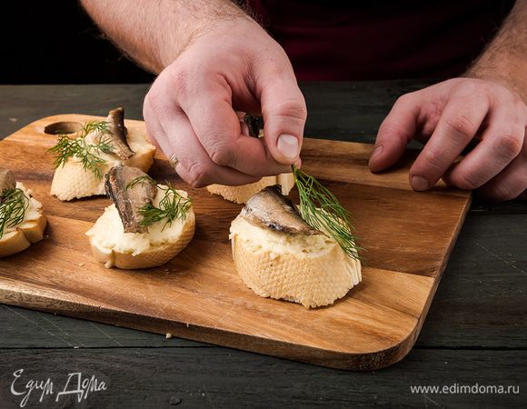 Сверху выложить шпроты.