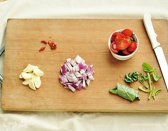 Нарезать лук, листья базилика и перец чили. Чеснок нарезать на тонкие пластины, помидоры разрезать пополам.