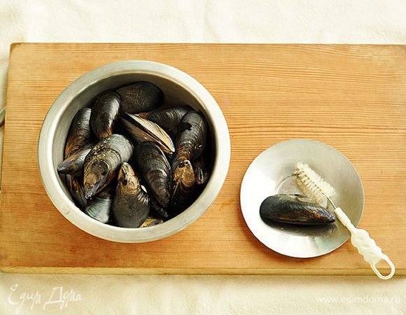 Промыть мидии под водой и почистить щеткой.