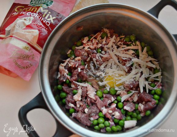 Для начинки соедините в кастрюле порезанное мясо, размороженный зеленый горошек, тертый сыр и яйцо. 