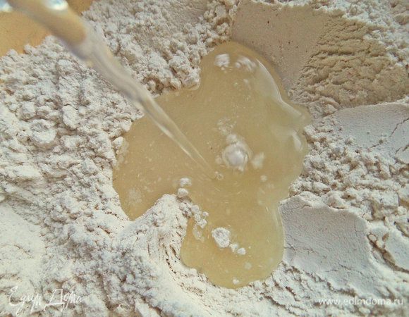 Сделать в муке ямку и влить воду комнатной температуры.